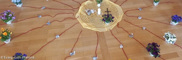 Blumenkreis mit Kerze in der Mitte